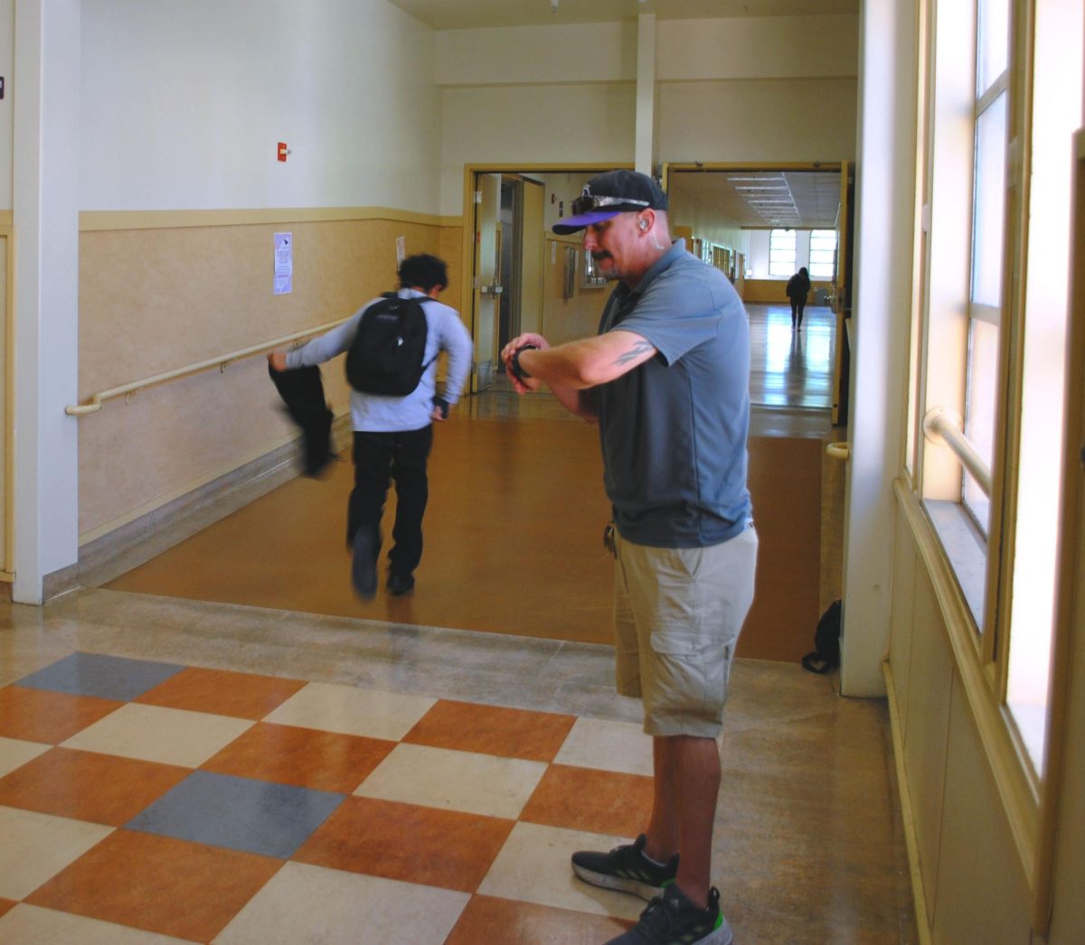 Campus security motivates students to get to class on time as the bell rings.