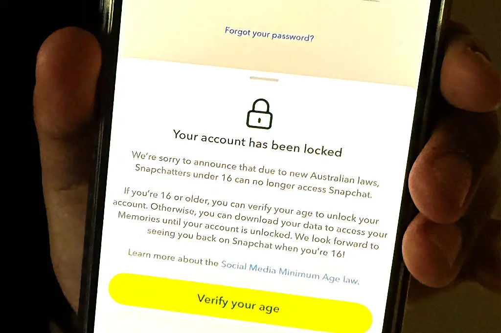 A 13-year-old boy displays a message on his mobile phone from social media platform Snapchat after his account was locked for age verification in Sydney on December 9, 2025. 