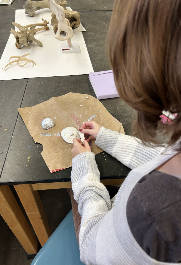Image of a student participating in art class through sculpture